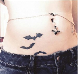 Matching bats tattoos and belly ring with chain