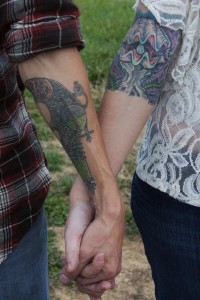 couple holding hands with tattoos