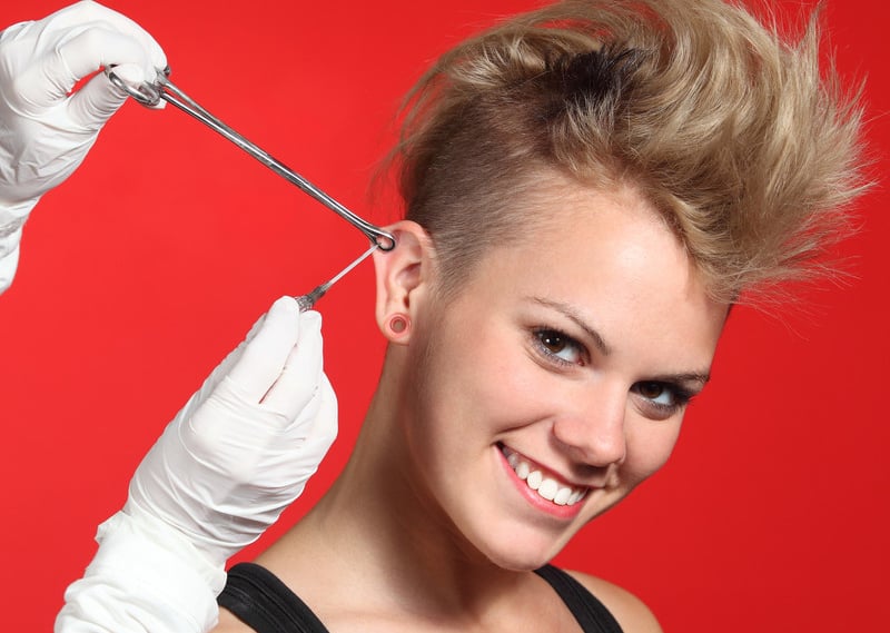 Woman getting upper cartilage pierced