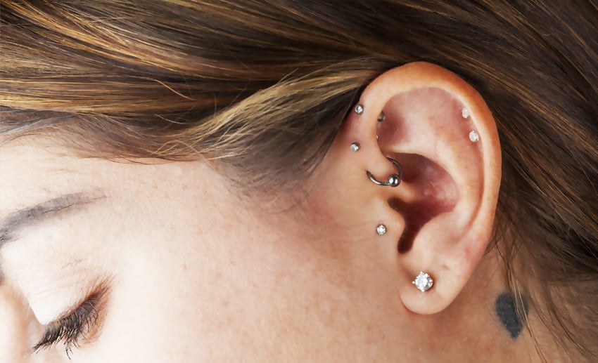 Multiple cartilage earrings on woman's ear