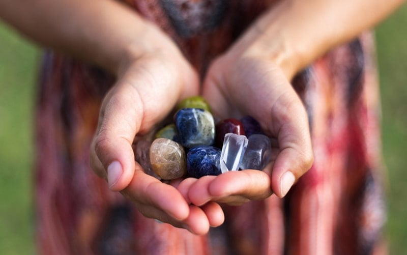 Woman holding a variety of gems and crystals