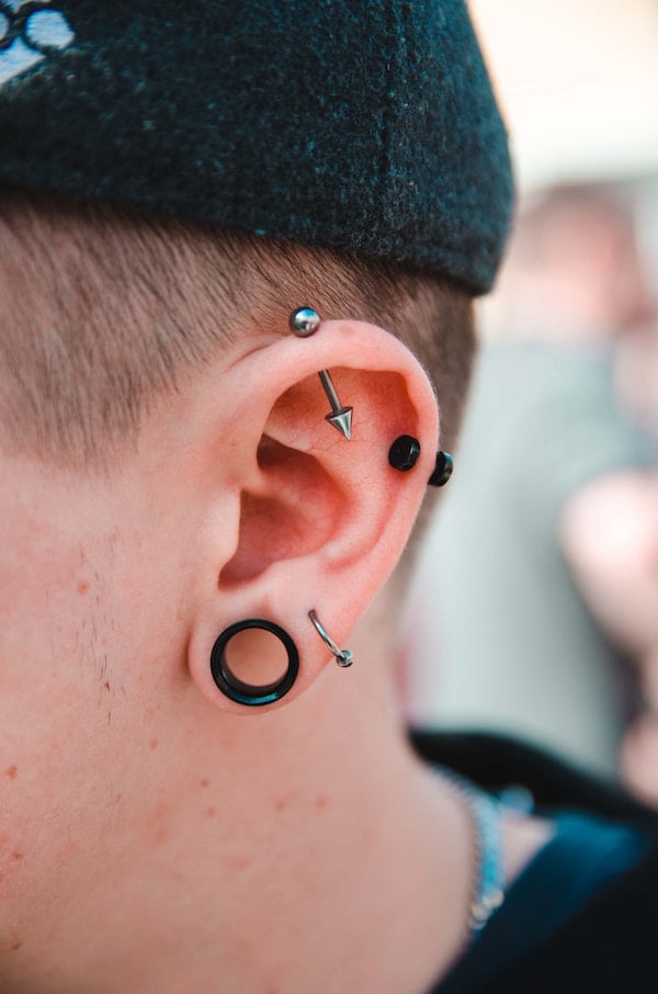 man with cartilage piercings and stretched lobe