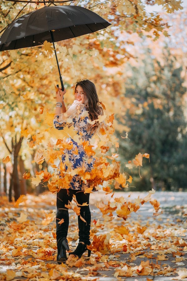 Woman playing in the fall leaves