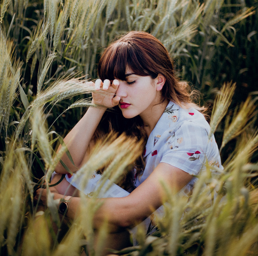 Girl with Bangs Looks Sad in a Field