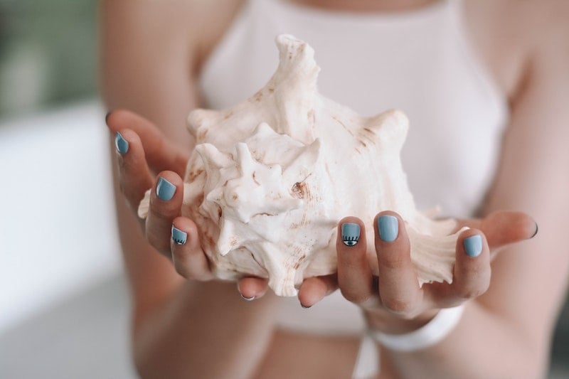 woman holding a conch shell