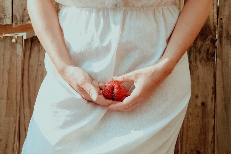 Woman Holding Strawberry in Vaginal Area to depict vch piercing