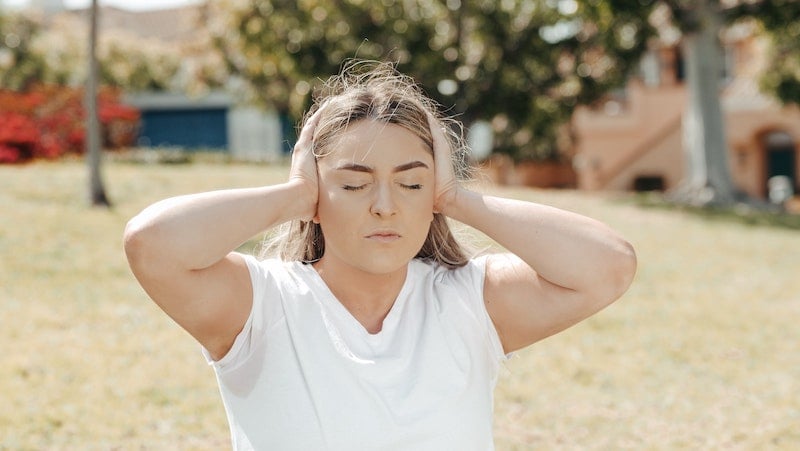 woman covering ears