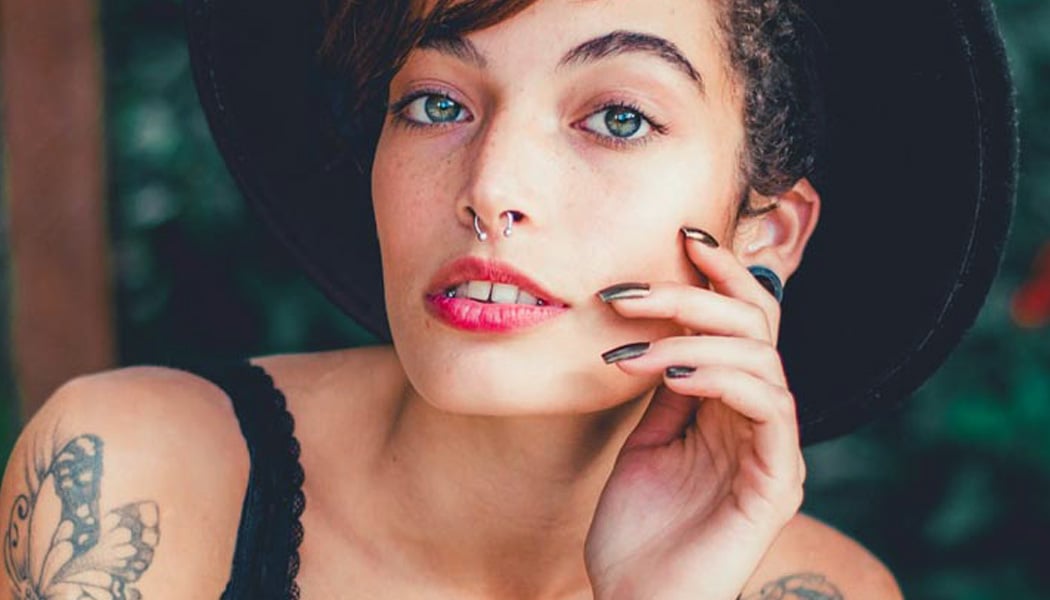Woman, hand on face, with septum piercing