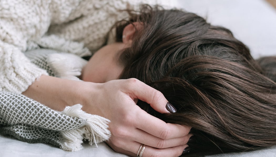 Woman laying down holding head