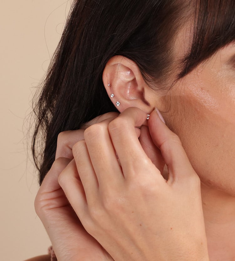 Woman inserting earrings