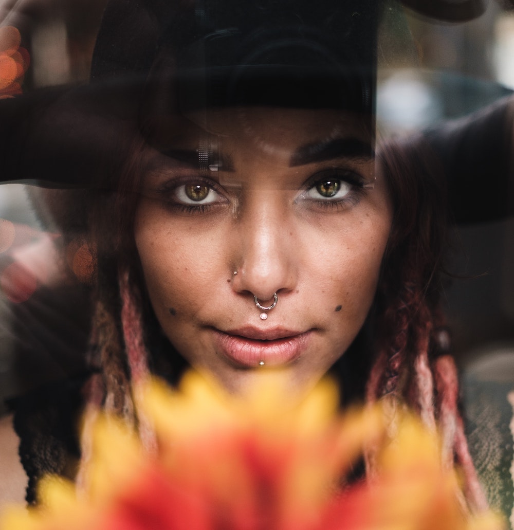 Alt Text: woman with multiple nose piercings, septum piercing, lip piercings